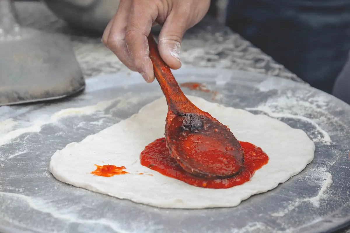 Pizza sauce on dough. Credit: Unsplash