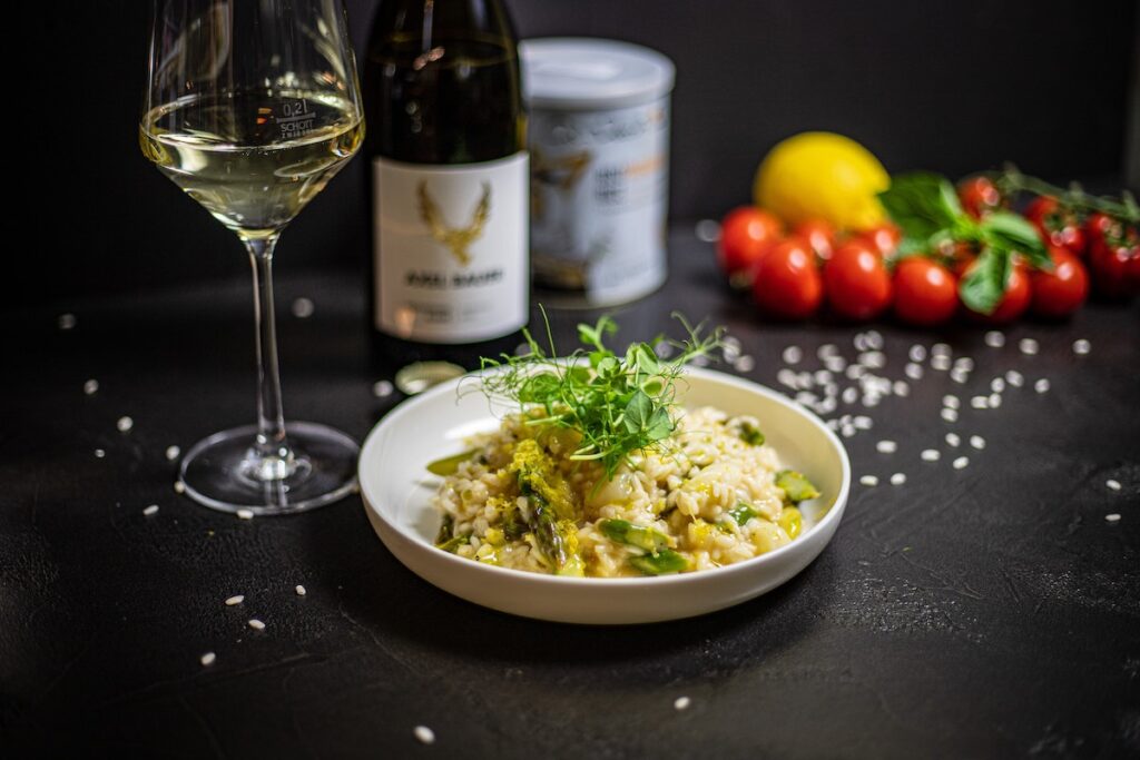 Risotto with bottle and glass of white wine. Credit: Unsplash