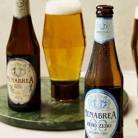 瓶和杯 Menabrea 啤酒。