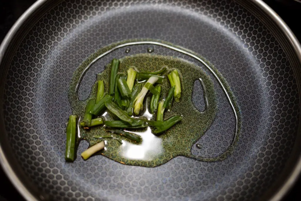 Frying spring onions in oil. Credit: Unsplash