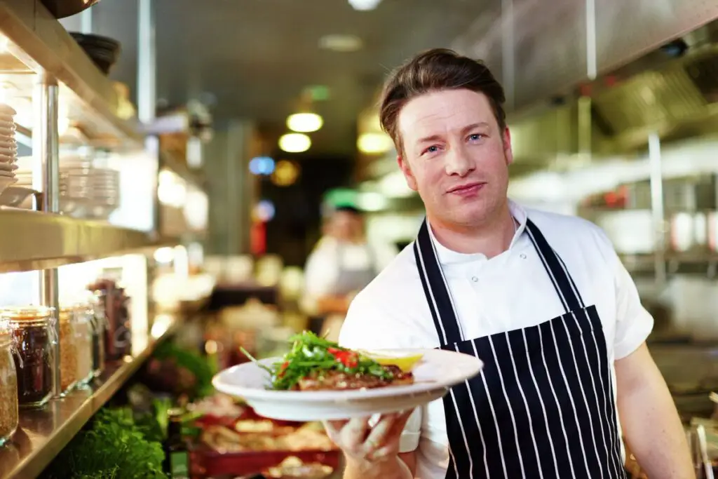 Jamie Oliver holding food in his old restaurant, Jamie's Italian.