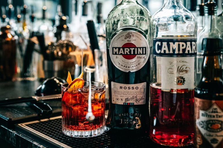 Glass and bottle of Campari, with a bottle of Martini.