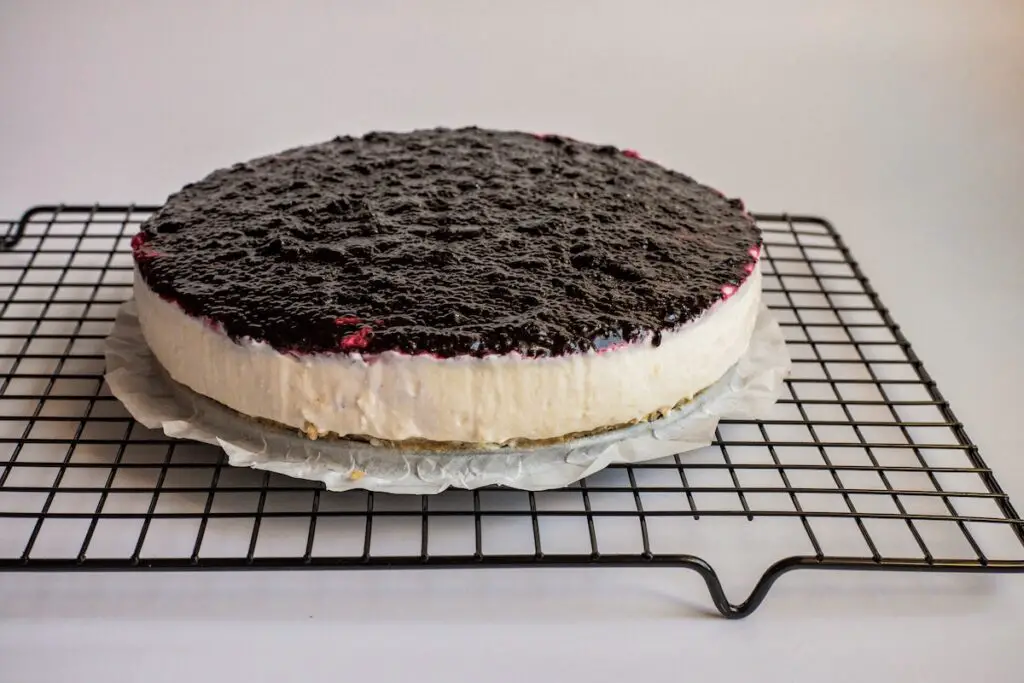 Cheesecake cooling on a wire rack.
