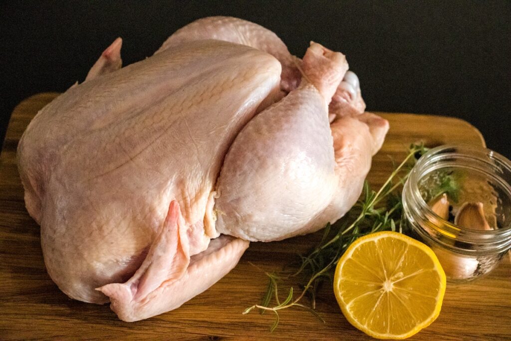 Full chicken with herbs and seasoning for brining.