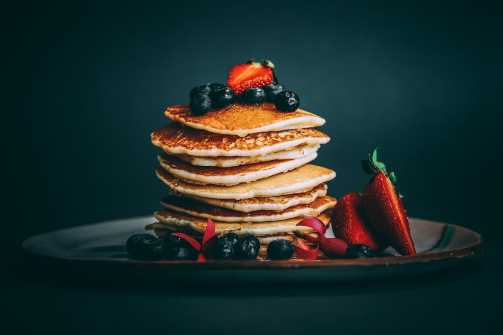 Stacked pancakes with fresh fruit.