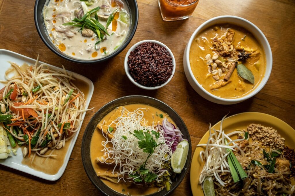 Variety of Thai noodle dishes on a table.