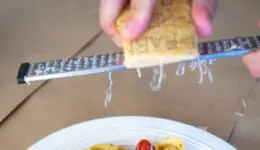 Shaving parmesan cheese over pasta. Credit: Unsplash