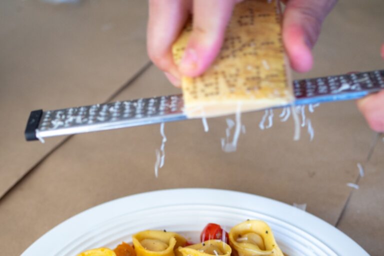 Shaving parmesan cheese over pasta. Credit: Unsplash
