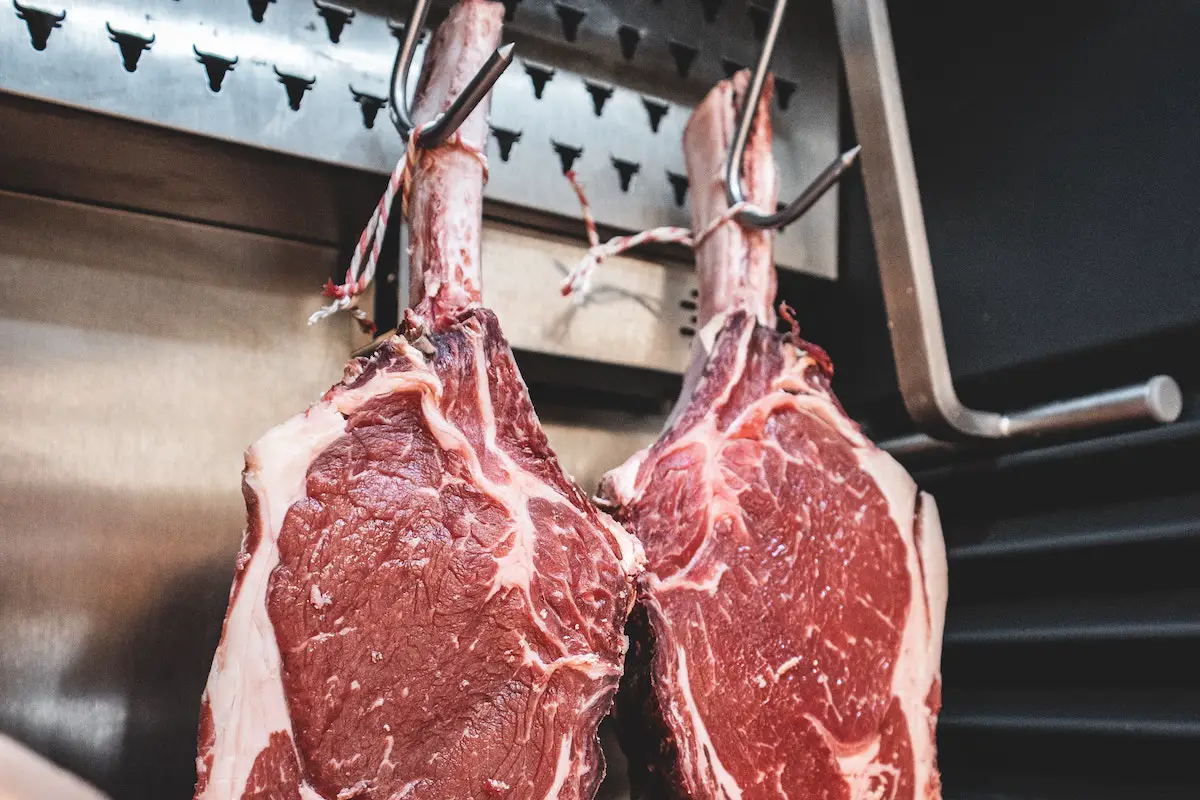 Tomahawk steaks hanging at a butchers. Credit: Unsplash