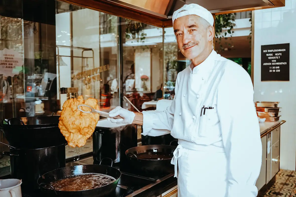 A chef with a fried Schnitzel.