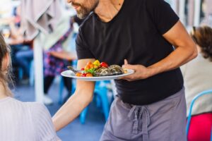 Waiter serving food at a restaurant.
